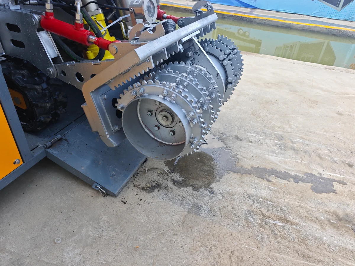 Silver heavy-duty breaker head installed on a desilting robot