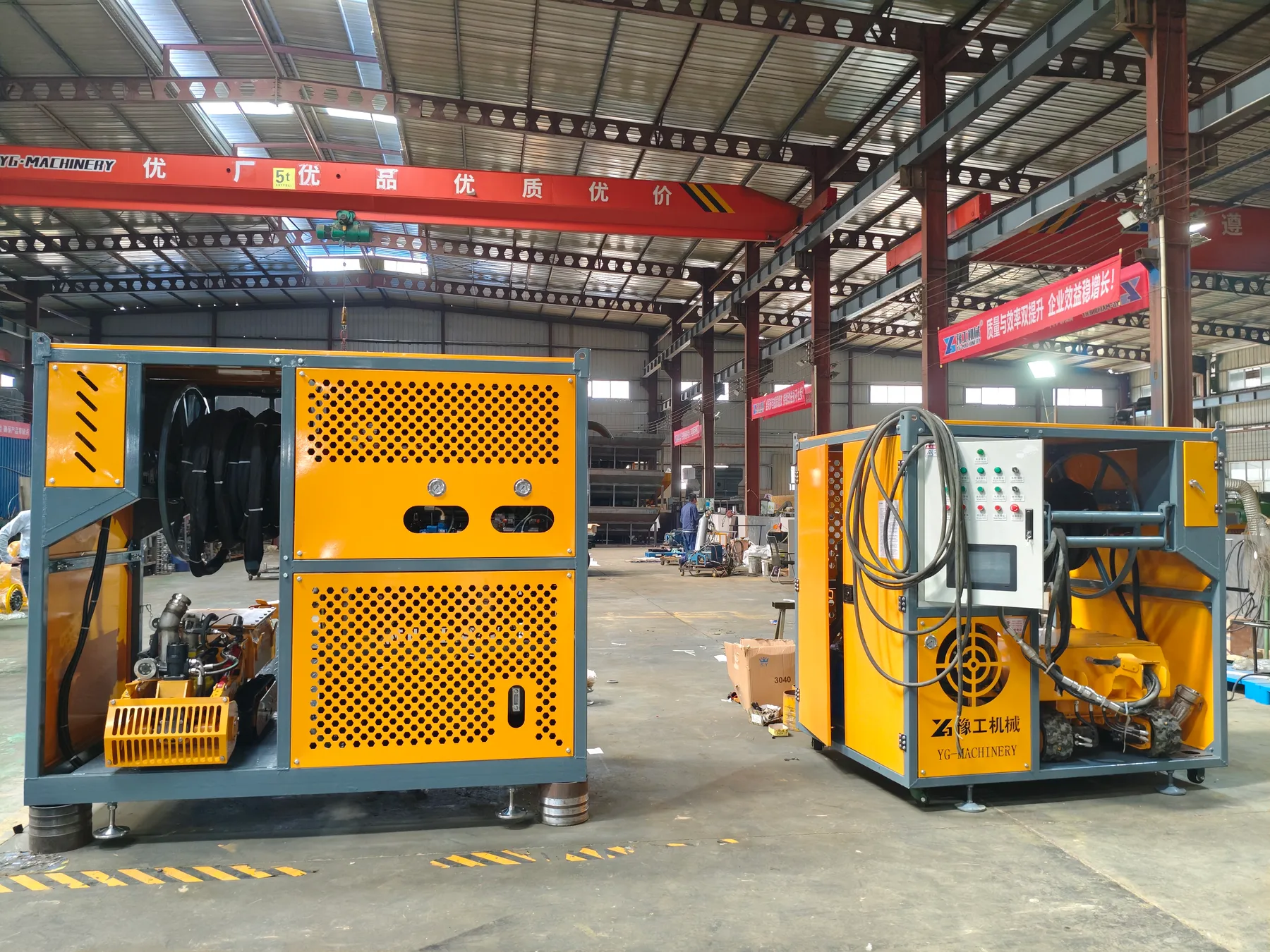 Two orange crawler desilting robot systems inside the factory